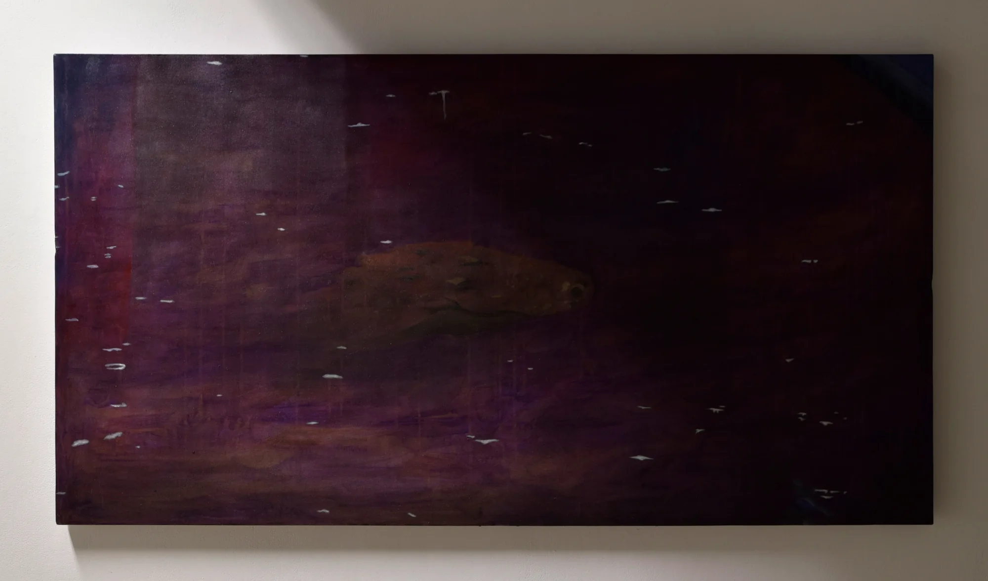 Peinture pourpre très sombre d'un poisson dérivant sous une surface nocturne piquetée de gouttes pâles.